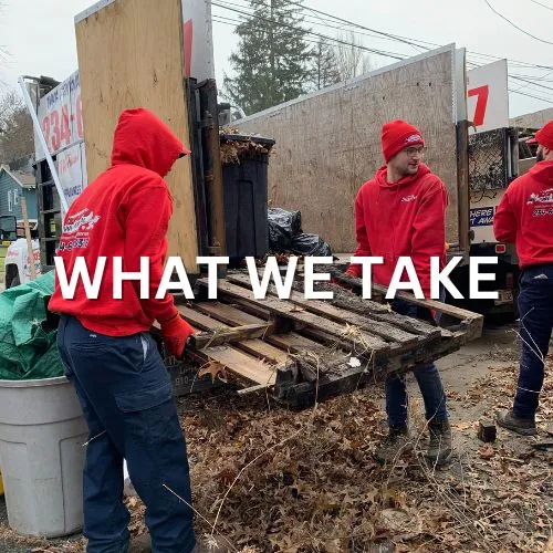 Two Express Junk Removal team members loading a pallet into their truck.