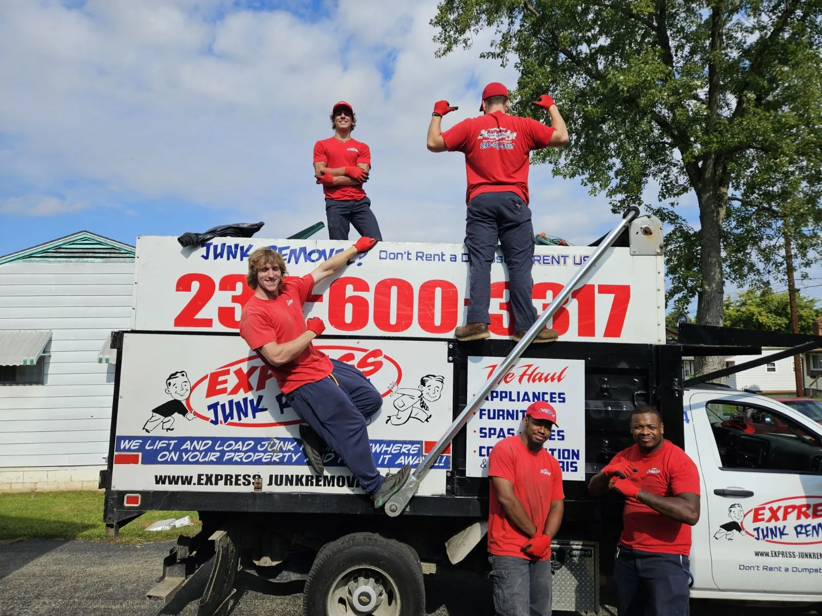Express Junk Removal crew members in red uniforms on and around their truck