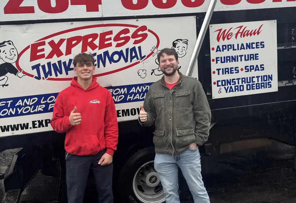 Happy customer giving a thumbs up with an Express Junk Removal crew member in front of the truck