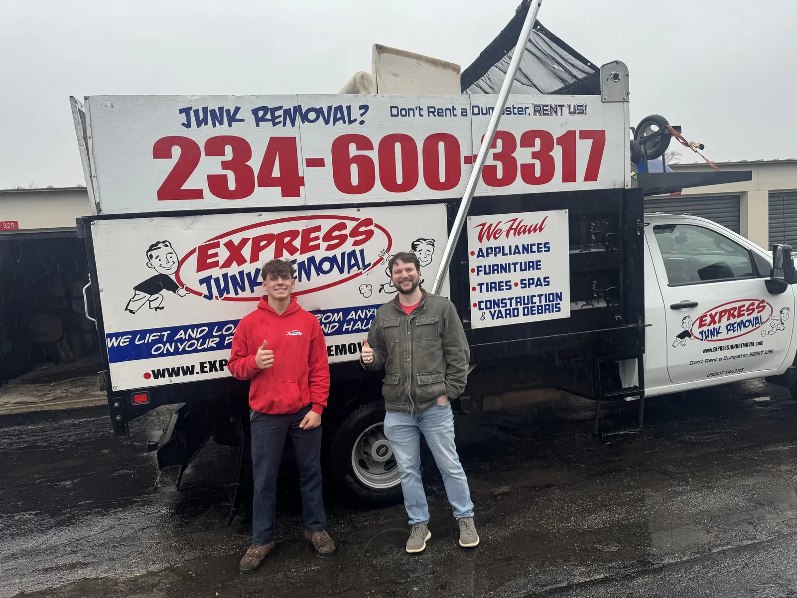 Happy customer giving a thumbs up with an Express Junk Removal crew member at a storage unit cleanout